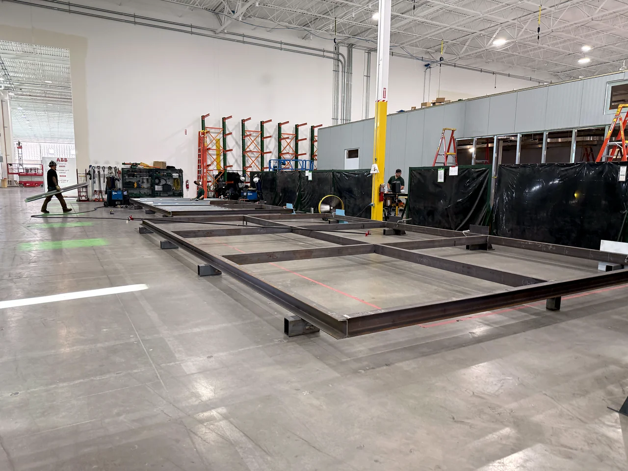 Steel bases laid out across the EIG electrical prefabrication floor