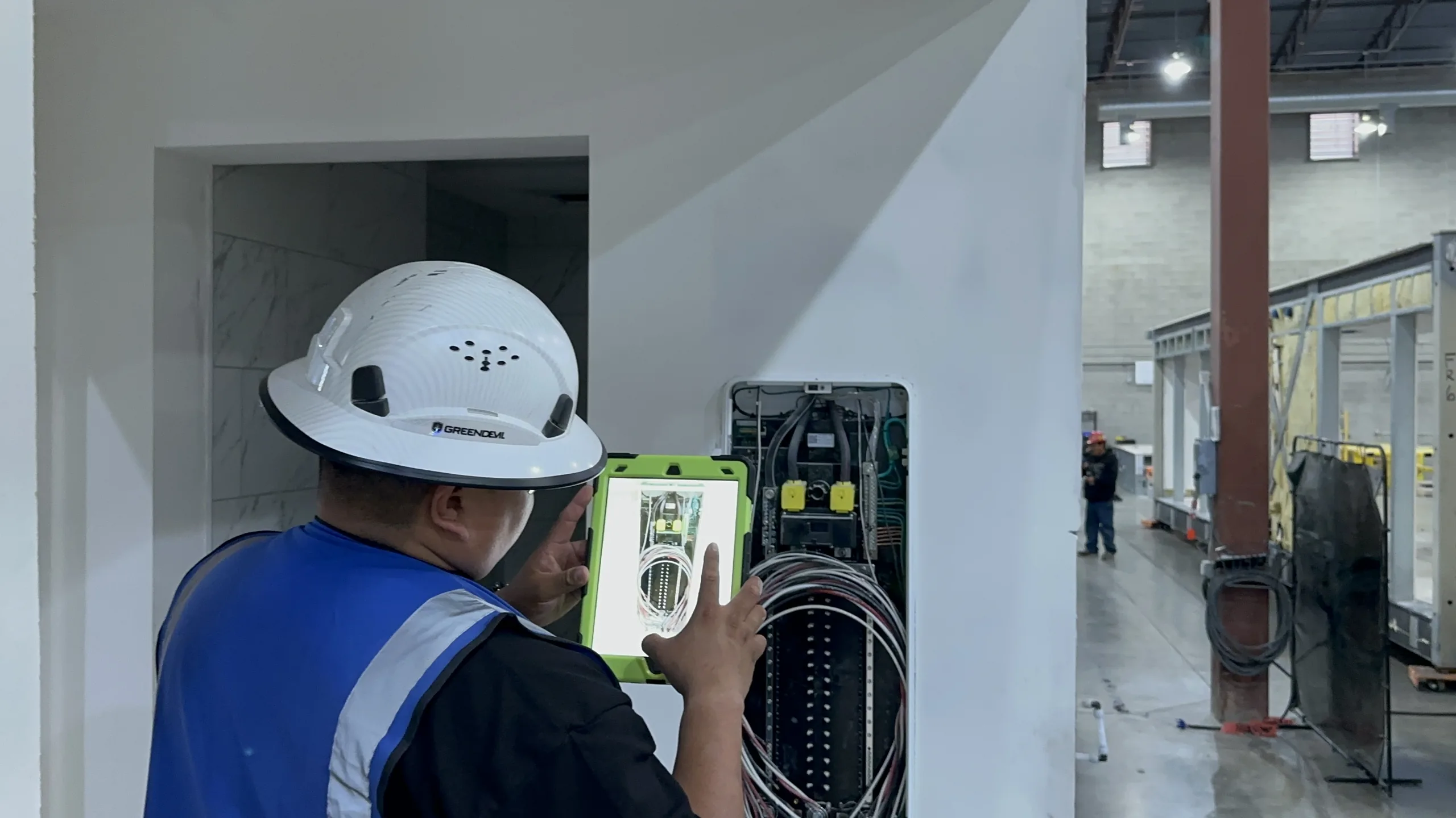 A technician testing an open electrical panel inside a module